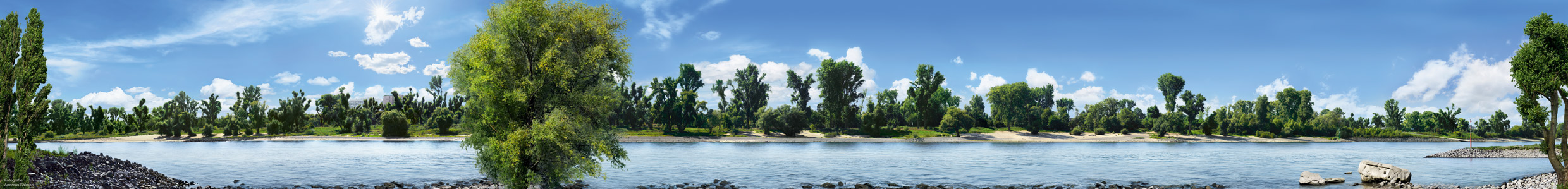 Photoshopmäßig bearbeitetes großformatiges Panoroma wie beim Fotografen Andreas Gursky zusammengebaut aus unzähligen Einzelfotos. 1,6 km Rhein und Rheinufer von Lörick mit Bepflanzung und blauem Himmel werden auf 9m Länge hinter Acryl abgebildet und hängen im Foyer des Rheinoffice in Düsseldorf.